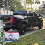 Black pickup truck alongside Titan Roofing sign