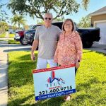 Couple posing in front of Titan Roofing signage