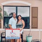 Couples posing by the Titan Roofing sign