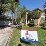 House showcasing a Titan Roofing sign in the yard area