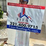 Person holding a Titan Roofing sign
