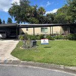 Titan Roofing sign in front of the house with a parked vehicle