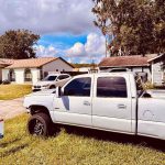 Titan Roofing sign next to the white vehicle