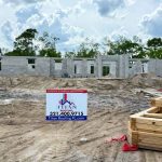 Titan Roofing sign positioned in front of a house under construction