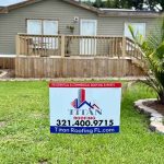 Titan Roofing sign positioned in front of an old house