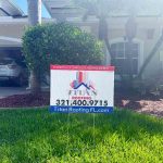 Titan Roofing signage set on a grassy lawn